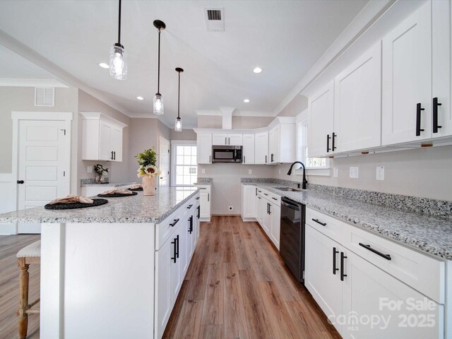 kitchen with crown molding, stainless steel microwave, a sink, visible vents, and dishwashing machine