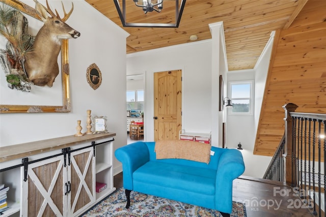 sitting room featuring wooden ceiling, wood finished floors, an upstairs landing, and crown molding