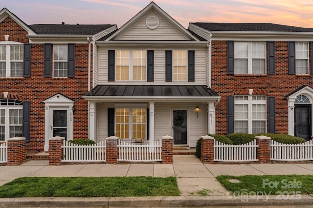 1720 Chamberside Dr, Rock Hill, SC 29730 - townhome / multi-family property with brick siding, a porch, a standing seam roof, and a fenced front yard