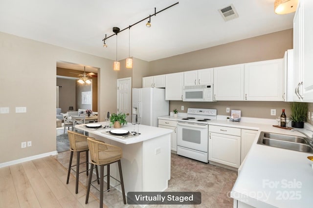 1720 Chamberside Dr, Rock Hill, SC 29730 - kitchen with white appliances, a kitchen island, a sink, visible vents, and white cabinets