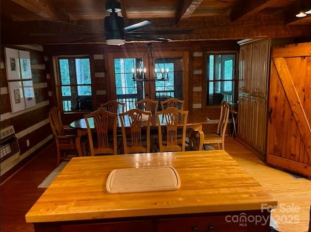 7810 Little Snowbird Rd, Robbinsville, NC 28771 - dining space featuring wooden walls, wood finished floors, healthy amount of natural light, a chandelier, and a wood ceiling with exposed beams