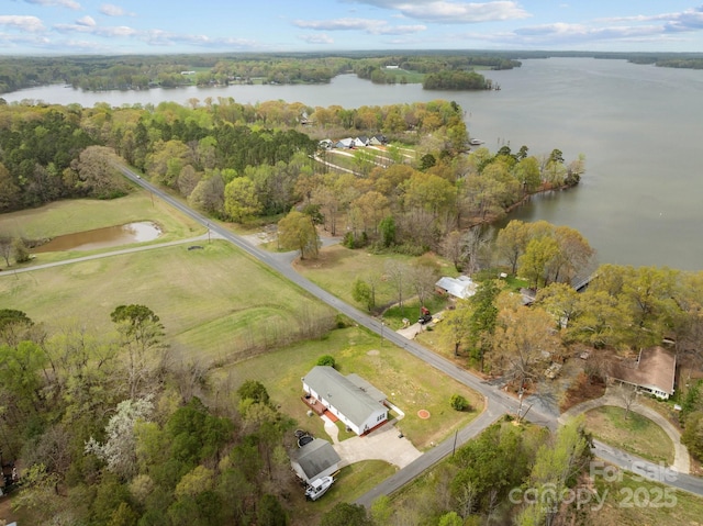 aerial view with a water view and a wooded view