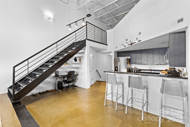 925 Westmere Ave, Charlotte, NC 28208 - kitchen with finished concrete flooring, visible vents, a towering ceiling, stainless steel appliances, and dark countertops