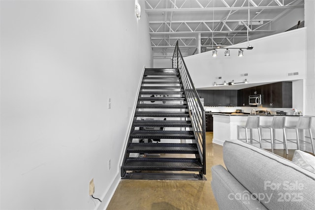 925 Westmere Ave, Charlotte, NC 28208 - stairway with baseboards, a towering ceiling, visible vents, and finished concrete floors