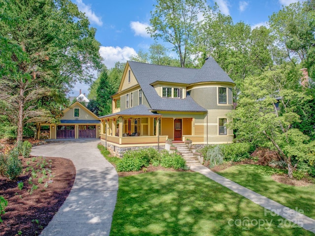 156 Cumberland Ave, Asheville, NC 28801 - victorian-style house with covered porch, a shingled roof, a front yard, an outbuilding, and a detached garage