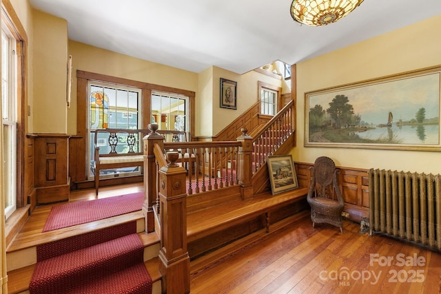 156 Cumberland Ave, Asheville, NC 28801 - stairway with radiator heating unit, hardwood / wood-style flooring, and a wainscoted wall
