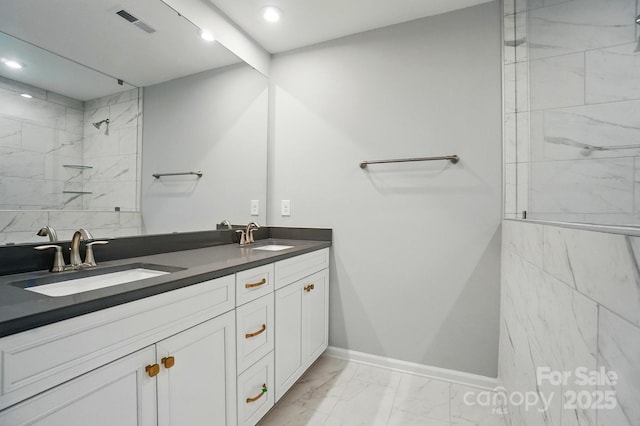 bathroom with a sink, tiled shower, marble finish floor, and recessed lighting