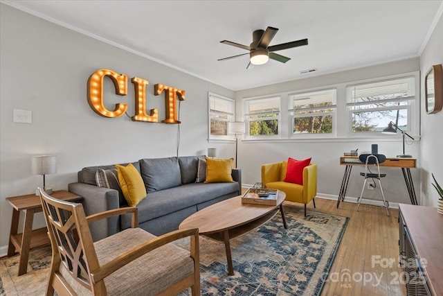 living area featuring ceiling fan, visible vents, light wood-type flooring, and a wealth of natural light