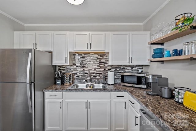 kitchen featuring white cabinetry, tasteful backsplash, crown molding, a sink, and appliances with stainless steel finishes