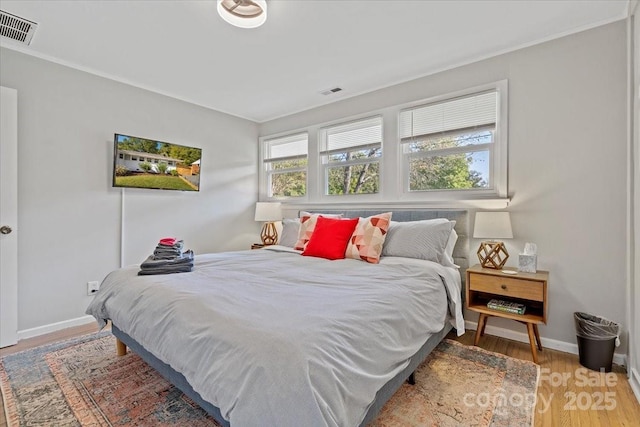 bedroom with baseboards, visible vents, and light wood-type flooring