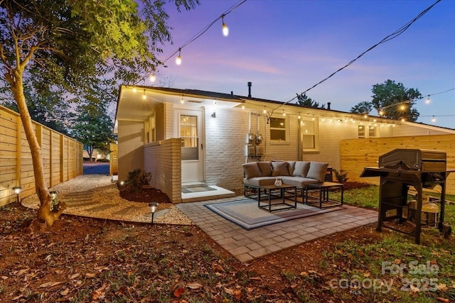 back of house featuring fence, an outdoor living space, and a patio