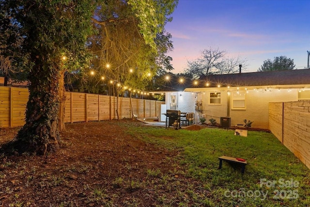 view of yard featuring a fenced backyard, central air condition unit, and a patio