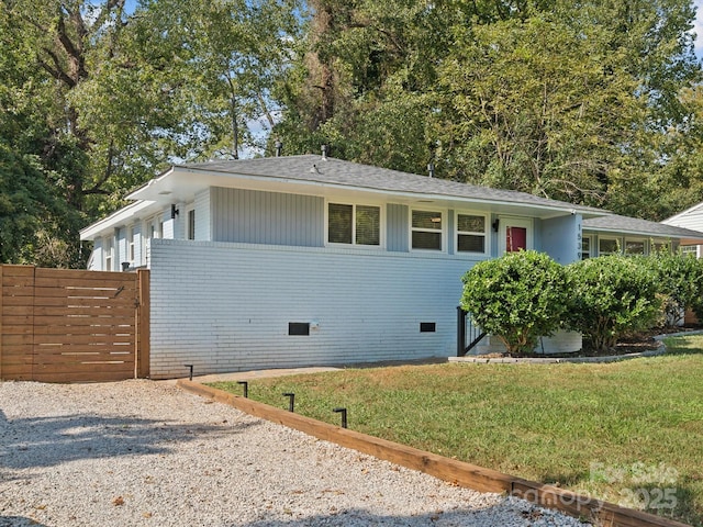 ranch-style house with a front yard, crawl space, a shingled roof, and fence