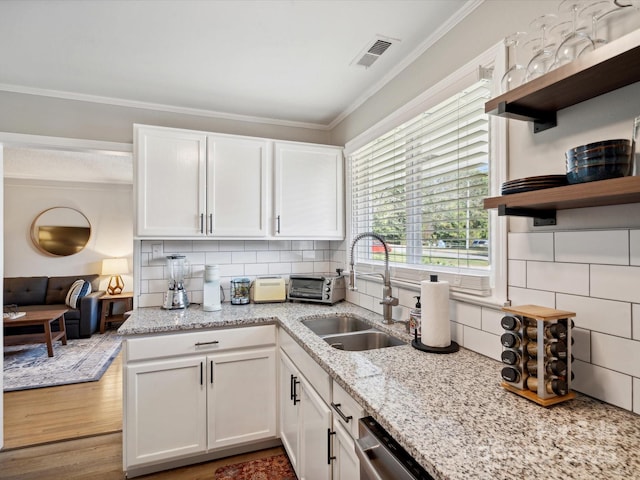 kitchen with open shelves, ornamental molding, decorative backsplash, a sink, and visible vents