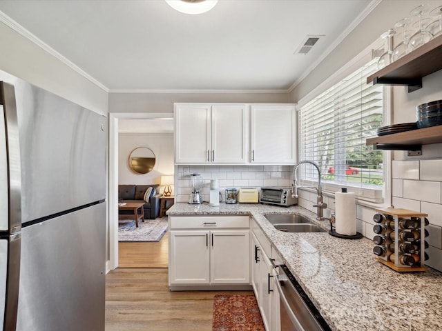 kitchen featuring visible vents, stainless steel appliances, a sink, open shelves, and light wood-style floors