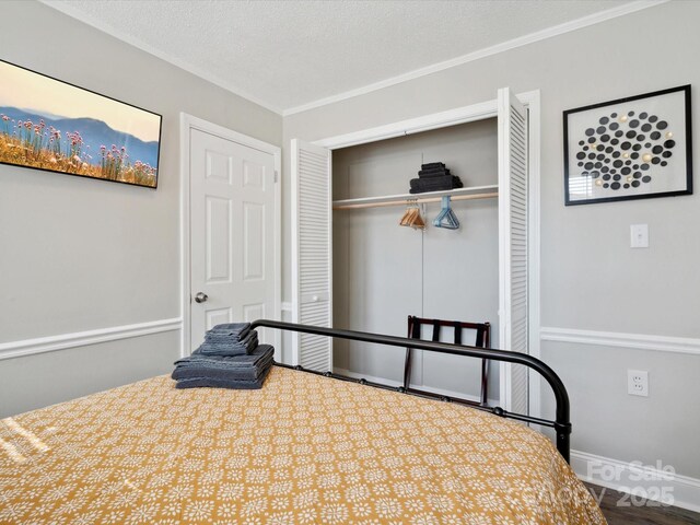 bedroom featuring a closet, a textured ceiling, baseboards, and crown molding