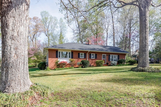 single story home with brick siding, a front lawn, and a chimney