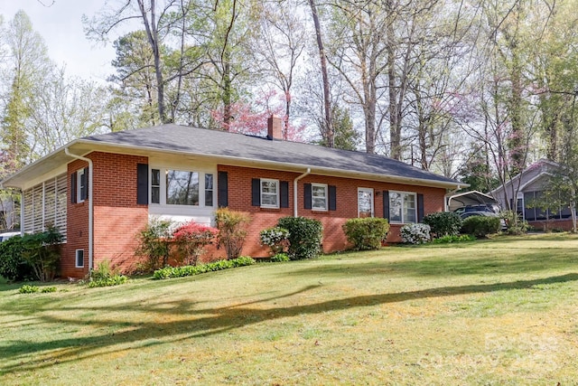 view of front of property featuring brick siding, a front lawn, and a chimney