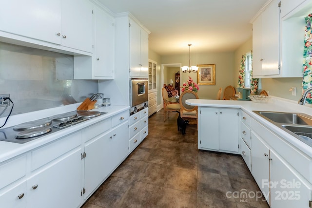 kitchen featuring light countertops, oven, a notable chandelier, and electric cooktop