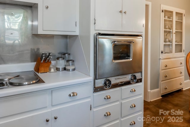 kitchen featuring tasteful backsplash, white cabinetry, and light countertops