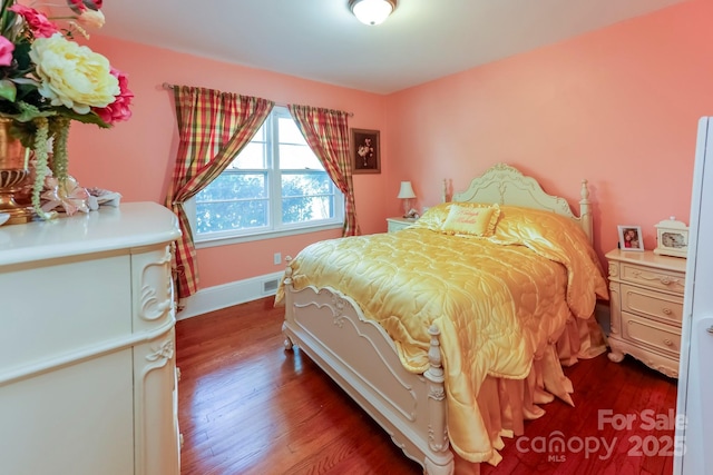 bedroom with dark wood-type flooring, baseboards, and visible vents