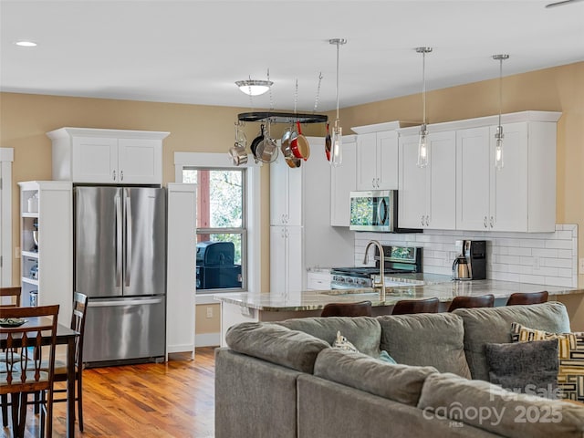 219 Westover Aly, Asheville, NC 28801 - kitchen with open floor plan, backsplash, appliances with stainless steel finishes, and white cabinets