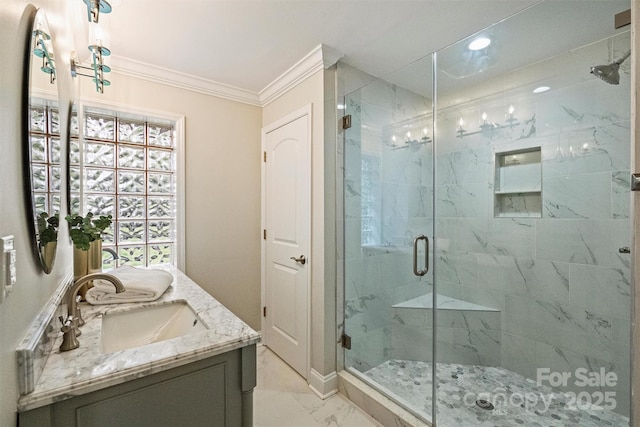 full bath with a stall shower, crown molding, a sink, marble finish floor, and double vanity