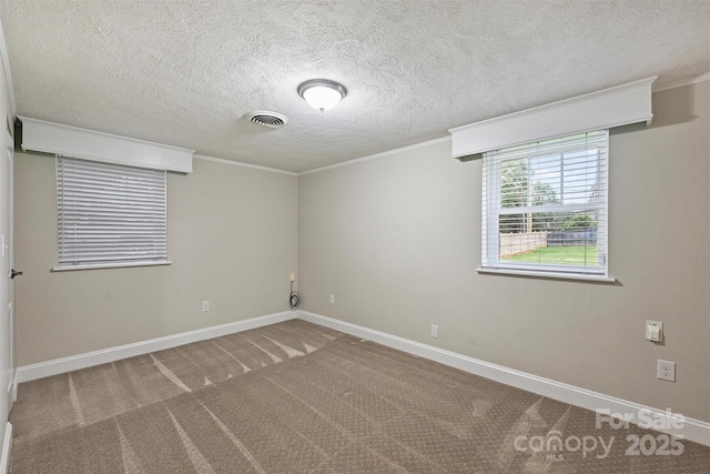 spare room with baseboards, visible vents, crown molding, and carpet flooring