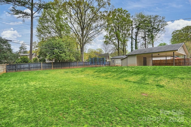 view of yard featuring a trampoline and a fenced backyard