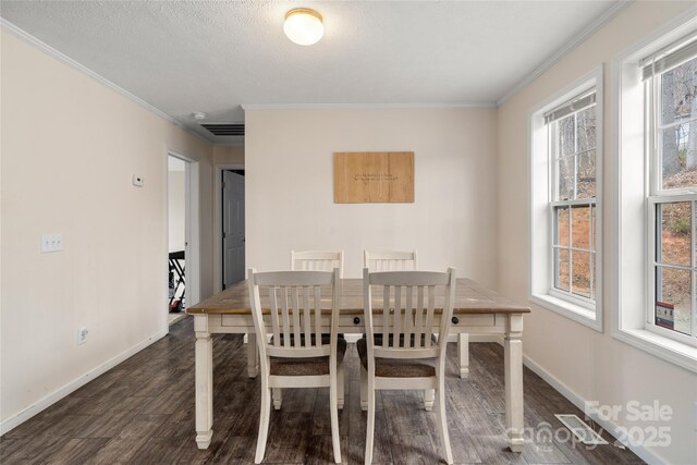 dining space with crown molding, baseboards, a textured ceiling, and wood finished floors