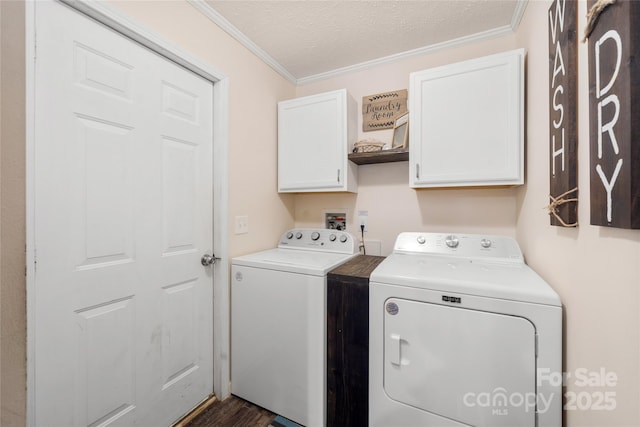washroom featuring washer and clothes dryer, cabinet space, a textured ceiling, and crown molding