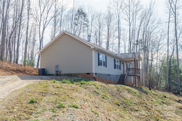 view of property exterior with cooling unit, driveway, crawl space, and stairway