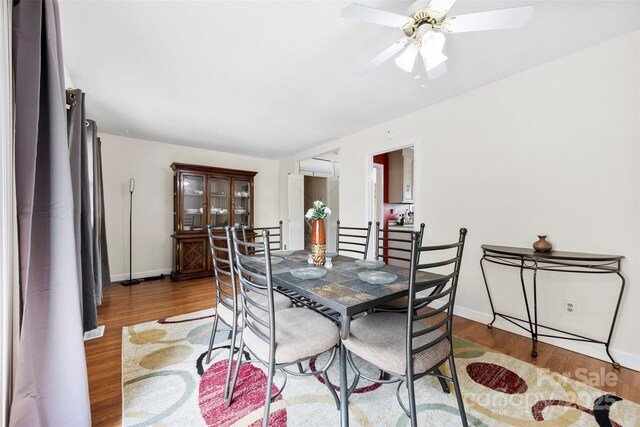 dining space featuring baseboards, wood finished floors, and a ceiling fan