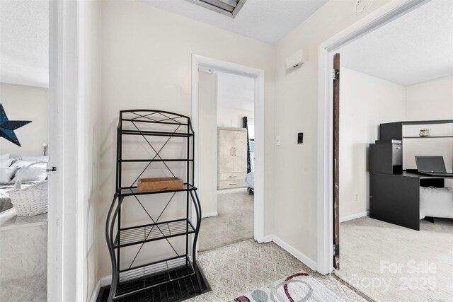 hallway with baseboards and carpet