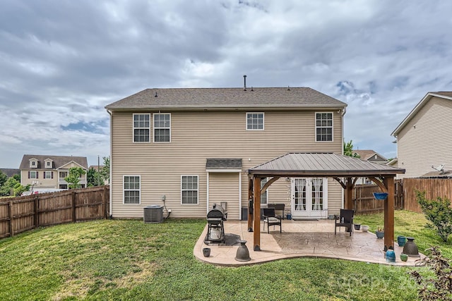 back of house with a lawn, a gazebo, central air condition unit, and a fenced backyard