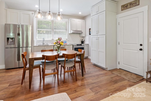 dining space featuring light wood-style floors and recessed lighting