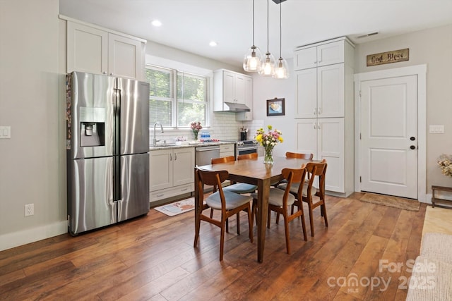dining area with hardwood / wood-style flooring and recessed lighting
