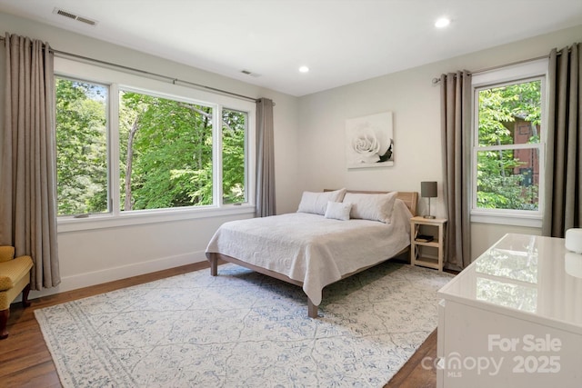bedroom featuring multiple windows, wood finished floors, baseboards, and recessed lighting