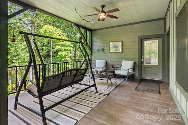 sunroom featuring a ceiling fan, an outdoor living space, and healthy amount of natural light