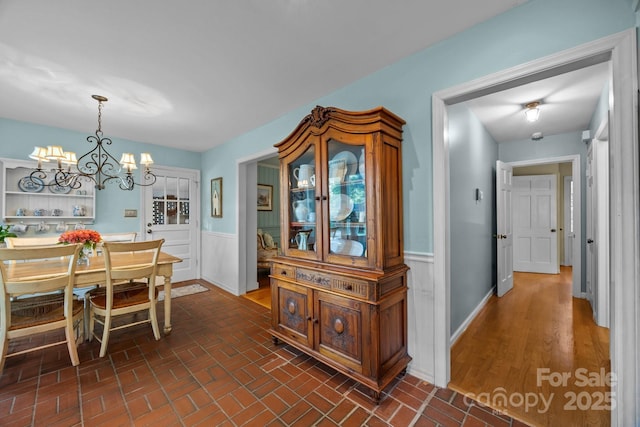 5510 Sardis Rd, Charlotte, NC 28270 - dining space featuring wainscoting, a chandelier, and brick patterned flooring