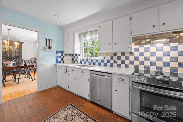 5510 Sardis Rd, Charlotte, NC 28270 - kitchen featuring appliances with stainless steel finishes, under cabinet range hood, a sink, light countertops, and a wainscoted wall