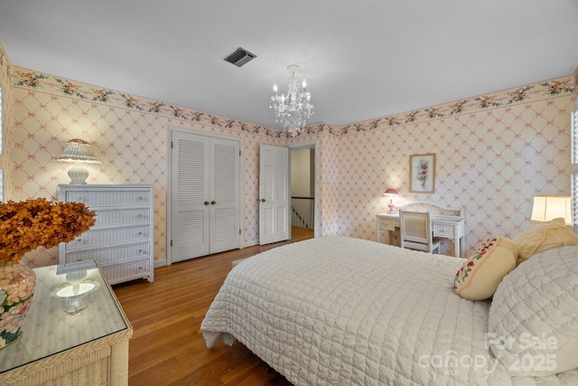 5510 Sardis Rd, Charlotte, NC 28270 - bedroom featuring a chandelier, wood finished floors, a closet, wallpapered walls, and baseboards