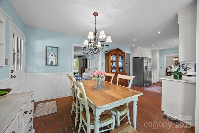 5510 Sardis Rd, Charlotte, NC 28270 - dining area featuring wainscoting, brick flooring, and a chandelier