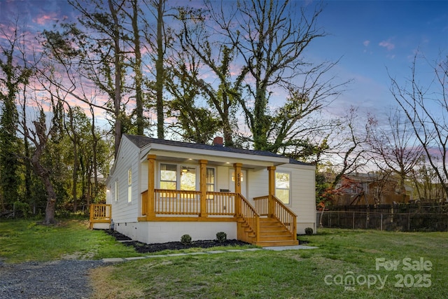bungalow featuring fence, a front lawn, and covered porch