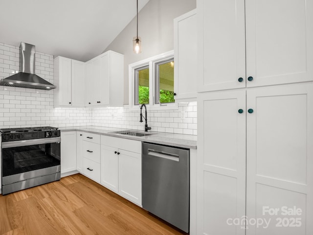 153 Old Lakey Gap Rd, Black Mountain, NC 28711 - kitchen with range with gas cooktop, wall chimney range hood, stainless steel dishwasher, a sink, and light wood-type flooring