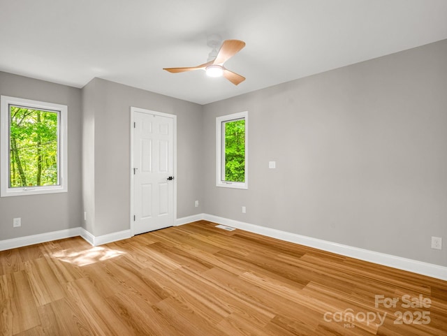 153 Old Lakey Gap Rd, Black Mountain, NC 28711 - unfurnished bedroom with baseboards, multiple windows, and light wood-style floors