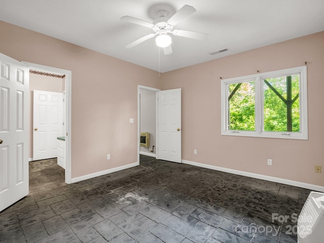 153 Old Lakey Gap Rd, Black Mountain, NC 28711 - unfurnished bedroom featuring baseboards, a ceiling fan, dark stone finish floors, and heating unit