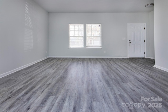 spare room featuring wood finished floors and baseboards
