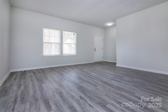 empty room with baseboards and wood finished floors