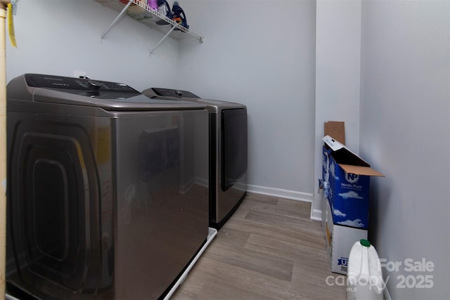 laundry room featuring washer and dryer, laundry area, baseboards, and wood finished floors